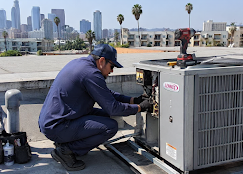 Arctic HVAC technician working on commercial rooftop unit with LA skyline